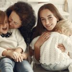 A joyful family gathering in a cozy kitchen with three generations bonded in happiness.