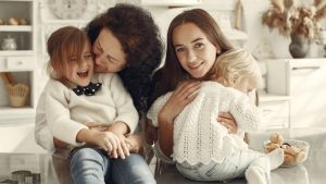 A joyful family gathering in a cozy kitchen with three generations bonded in happiness.